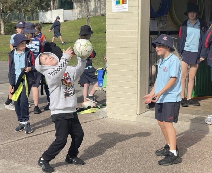 Two students playing with a ball