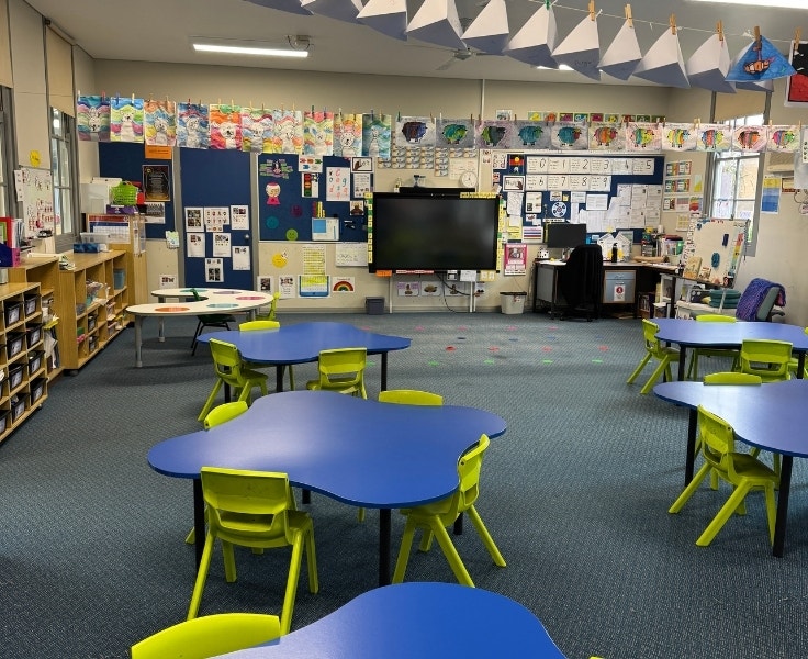 Classroom with blue desks and green chairs