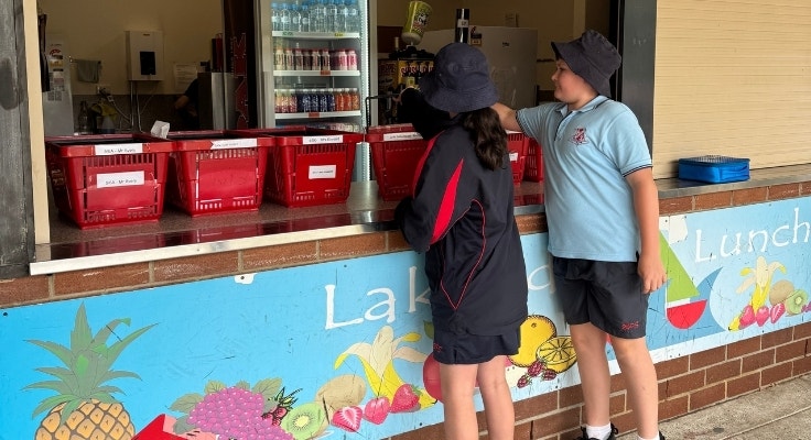 Two students collecting lunch orders from the canteen